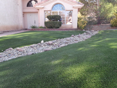 Artificial grass yard with landscape rock
