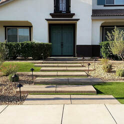 Stamped concrete entry steps with desert landscape and synthetic lawn