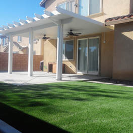 Insulated patio cover with ceiling fans and artificial turf lawn'